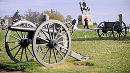A visitor walks along the Union Army artillery pieces on Cemetery Ridge.