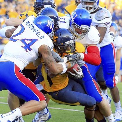 Kansas' Bradley McDougald (24) and Ben Heeney (31) tackle Tavon Austin in the first quarter.