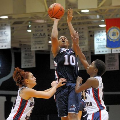 Duquesne junior Wumi Agunbiade gets a shot off Sunday as Robert Morris' Ashley Ravelli, left, and Jasmine Tate defend.