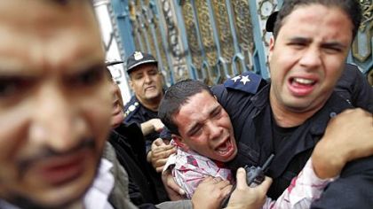 Egyptian police protect an opposition demonstrator after a scuffle with members of the Muslim Brotherhood and supporters of Egypt's Islamist President Mohammed Morsi during clashes outside the presidential palace in Cairo on Wednesday.
