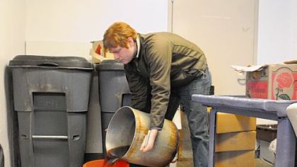 Travis Mecum, an Energy Corps Fellow of GTECH,  collects waste oil from the kitchen of Phipps Conservatory in Oakland.
