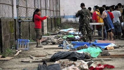 Residents try to identify the bodies of relatives in New Bataan, Compostela Valley province Wednesday, a day after Typhoon Bopha hit the province.