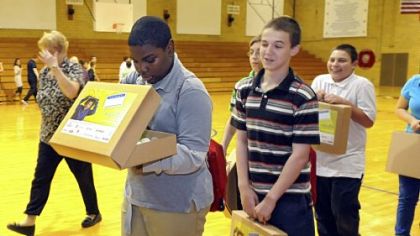 Tayvon McMillan, a seventh-grader at Founders' Hall Middle School in McKeesport, looks into a "briefcase" full of school supplies and personal items from The Education Partnership.