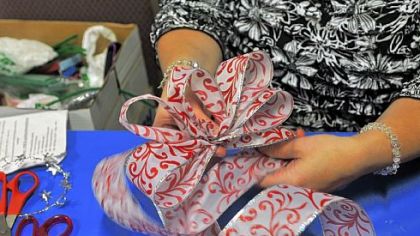 Michelle Kirk displays a tree-topper bow Sunday at Hamilton Presbyterian Church in Whitehall.