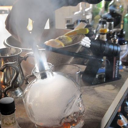 Liquor is infused with smoke before being transferred to a glass to make a Vieux Carre on Dutch DeVries' bar.