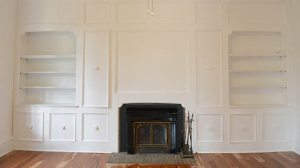 Off the living room is a 16- by 15-foot library or den with built-in bookshelves and cabinetry.