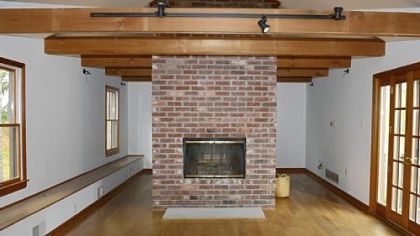 The media room, created by previous owners from part of a barn, has a beamed ceiling and double-sided wood-burning fireplace.