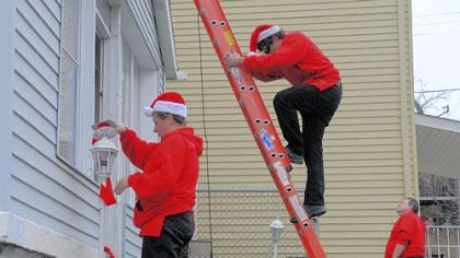 From left, Tammie Langston, Jake Colosimo and Ron Ventura, who work with Christmas Decor by E.L.F. Entertainment, decorate a home Saturday in South Oakland. The home is owned by James Chavis, who is on active duty in the Army. The company decorates homes for soldiers? families while they are deployed.