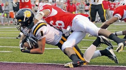North Allegheny's Brendan Coniker dives into the end zone for a touchdown despite the efforts of Wilson's Jesse Poore Saturday in a PIAA Class AAAA semifinal in Altoona.