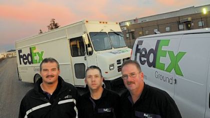Bill Floyd, Tom Dunlap and Paul Bullock in front of their delivery trucks and the Neville Island FedEx warehouse.