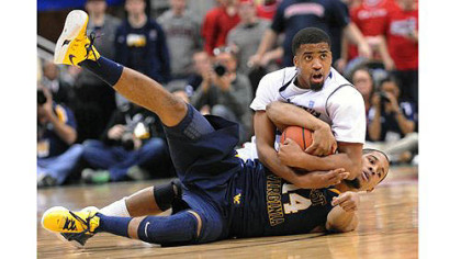 Duquesne's Sean Johnson fights for possession with West Virginia's Gary Browne in the second half.