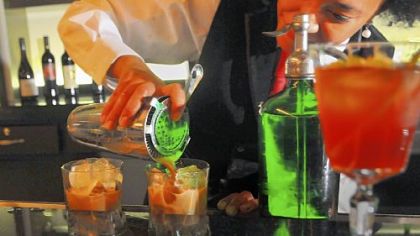 Dawn Young, the mixologist at Speakeasy, strains egg flips into glasses.
