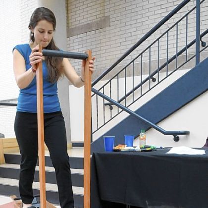 Kyra Gould demonstrates her team's Human-Powered Shallow Well Pump that uses a design based on a cross-country ski exercise machine.
