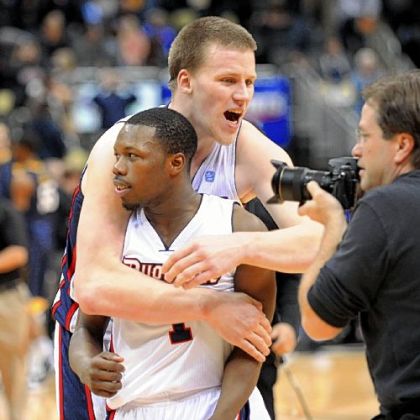 Duquesne's Martins Abele, rear, hugs teammate Derrick Colter Tuesday after the Dukes rallied to beat West Virginia, 60-56, at Consol Energy Center.
