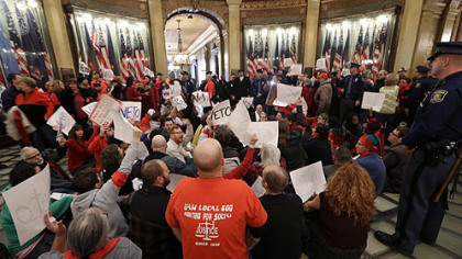Protesters sit in the rotunda of the State Capitol in Lansing, Mich., Tuesday, Dec. 11, 2012. The crowd is protesting right-to-work legislation passed last week.