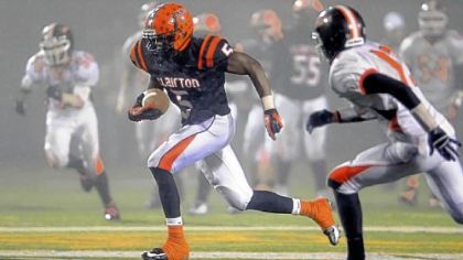 Clairton's Terrish Webb breaks through the gloom and mist at Deer Lakes High School and away from the Port Allegany defenseto gain yardage.