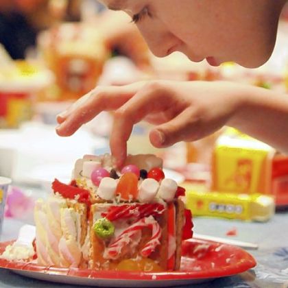 A light touch is required as Austin Krieger, 11, carefully places candy decorations on his gingerbread house.
