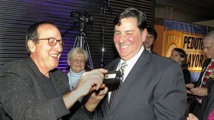 Former city council president Doug Shields, left, shows Councilman Bill Peduto the photo he just took as Mr. Peduto announced his run for mayor of Pittsburgh Thursday at the Crucible Building in the Strip District.