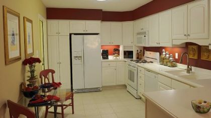 The eat-in kitchen features white Merillat cabinetry, a built-in pantry and Moen fixtures. A peninsula with seating separates the kitchen from the dining room.