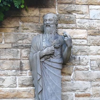Silenus, who holds grape vines in his hand, is one of a dozen art deco statues made by Paul Manship, considered the finest sculptor of his generation. Manship's design of these figures was influenced by a trip he took to Greece and the Korai figures he saw at the Acropolis.