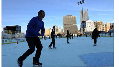 Brian Surmacz of the South Side takes a lap around the newly opened Penguins Pond at the Highmark Stadium in the South Side on Friday.