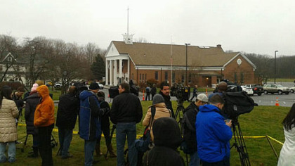 People gather outside Saint Rose of Lima Roman Catholic Church after those attending the noon mass were evacuated.