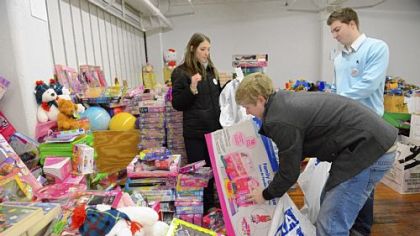 Volunteers, from left, Jayna Walters, 26, of Dormont, Brendan Orient, 23, of Mt. Lebanon and Alex Dziamniski, 23, of Whitehall sort toys Friday at the Toys for Tots open house in the Strip District.