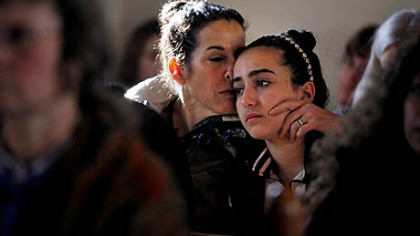 Elizabeth Bogdanoff, left, kisses her daughter Julia, 13, both of Newtown, Conn., during a prayer service Saturday at St. John's Episcopal Church in Newtown.