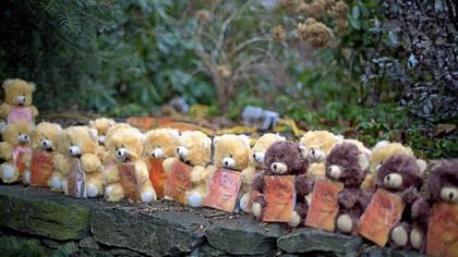 Teddy bears, each representing a victim of the Sandy Hook Elementary School shooting, sit on a wall at a sidewalk memorial Newtown, Conn.