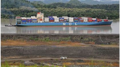 A tugboat escorts a large container ship near Cocoli, Panama.