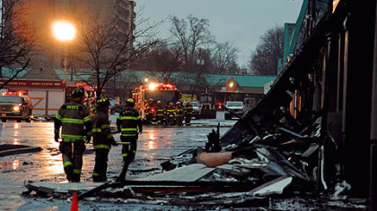 Firefighters look at the burned-out rubble of the Heights Plaza Tuesday in Harrison.