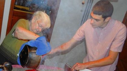 Dolly Ganster pours the hot candy from the pan while her grandson, Kenton Ganster, helps her scrape it out.