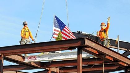Jason Shipely, left, and Scott Clark of Century Steel Erectors install the last beam during the topping out ceremony Friday at the construction site of the new Cardinal Wuerl North Catholic High School in Cranberry.