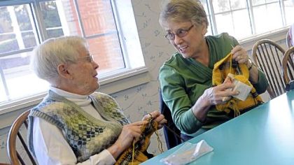 Lynda Simboli, left, and Janet Trebac chat while knitting sweaters for World Vision's Knit For Kids program at Longwood at Oakmont senior living complex. The group knits sweaters to donate to children in need.