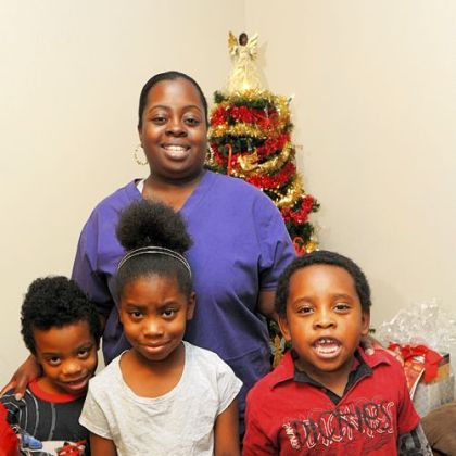 Erica Woods poses by the Christmas tree with her children, from left, Jose Baldino, 6; Airyona Baldino, 7, and Carlos Baldino, 5.