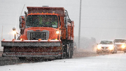 A snow plow spreads salt and sand yesterday near Omaha, Neb. A storm that has dumped more than a foot of snow in the Rocky Mountains is heading east and will begin to impact the Pittsburgh region by Friday.