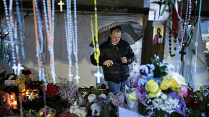 Ben Toby of Sandy Hook, Conn., visits a memorial to the Newtown shooting victims during a heavy rain early this morning.