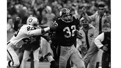 The Steelers' Franco Harris, right, eludes a tackle attempt by the Raiders' Jimmy Warren on the way to scoring on a play known as the "Immaculate Reception."