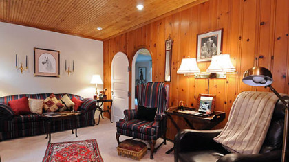 The 16- by 11-foot den has an arched doorway and tongue-and-groove, knotty-pine paneling on three walls and the ceiling.