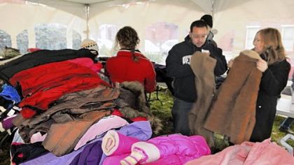 In the "Coat Tent," Ross Flynn and his mother, Nancy Flynn, sort coats Friday at the Light of Life Rescue Mission on the North Side. The group of volunteers also delivered hot meals to residents in 16 local high-rises and group homes.