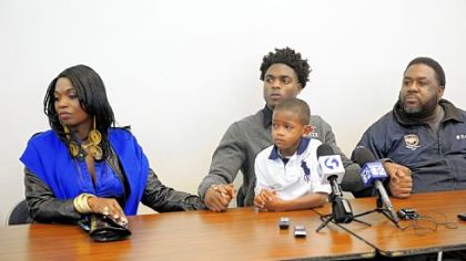 Robert Foster, center, with his brother Dior Adams, 6, holds hands with his mother, Sherrice Clements, left, and his father, Robert Foster II, at a news conference Friday to announce his decision to attend Alabama next season.