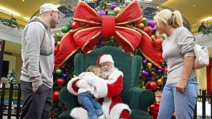 Myla Benoit, 3, of Ross Township, gives "Santa Ron" a hug after asking him to tell her parents, Joe Benoit, left, and Leslie Mozzetti, both 26, that she wants a puppy for Christmas.
