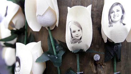Photos showing those killed in the shootings at Sandy Hook Elementary School are imprinted on faux roses at a memorial Saturday in Newtown, Conn.