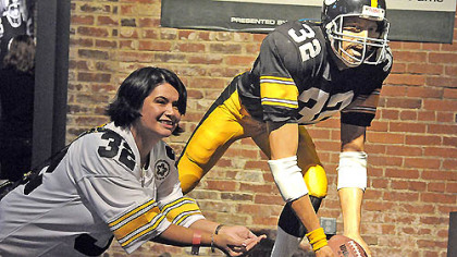 Tess Barker from Iowa City poses for a photograph with the Franco Harris Immaculate Reception statue at the Heinz History Center following today's session celebrating the 40th anniversary of the event.