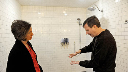Neil Alexander and his wife, Suzanne, talk in the bathroom attached to the newly renovated master suite in their house in O'Hara. Neil, who was diagnosed with amyotrophic lateral sclerosis in 2011, says that while he can drive just fine, holding a bar of soap is difficult. One feature of the wheelchair-accessible bathroom is soap dispensers that bypass the need for Neil to grip a bar of soap.
