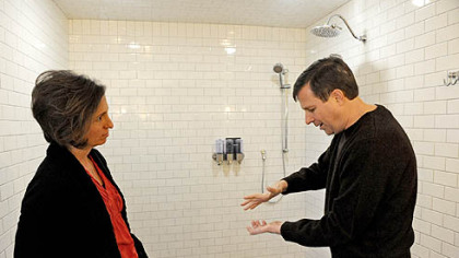 Neil Alexander and his wife, Suzanne, talk in the bathroom attached to the newly renovated master suite in their house in O'Hara. Neil, who was diagnosed with amyotrophic lateral sclerosis in 2011, says that while he can drive just fine, holding a bar of soap is difficult. One feature of the wheelchair-accessible bathroom is soap dispensers that bypass the need for Neil to grip a bar of soap.