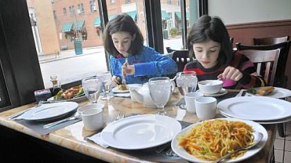 Marissa Alpern, 10, left, and Sylvia Alpern, 8, of Mt. Lebanon have lunch with their parents Tuesday at the China Palace on Walnut Street in Shadyside.