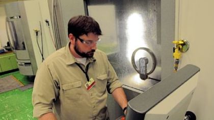 Ben Brewster, a toolmaker from Butler, cuts a component  for a stamping die within .00005 inch at Oberg Industries.