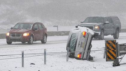 Inbound Interstate 279 traffic creeps past an overturned car in the median near the Mt. Nebo Rd. overpass this morning. With snow falling at over an inch an hour, PennDOT snow plow crews were working at their peak.