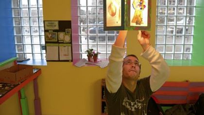 James Swonick, 27, of Shadyside, hangs lights Dec. 18 at the new Braddock Community Cafe.